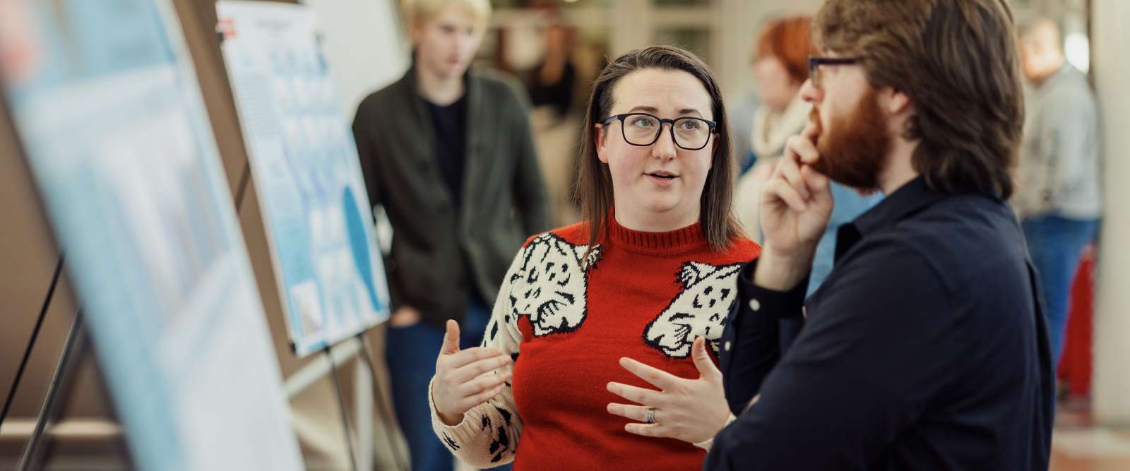 Two students look at a presentation during the Winter Academic Showcase poster session