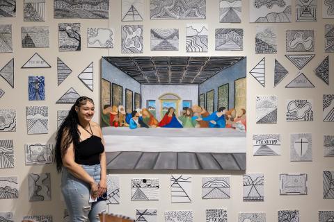 An Art and Design Student posing with their work
